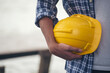 © aFotostock - Engineer man hands holding hardhat white work helmet hard hat for Civil Construction Engineering. Construction engineer man in safety suit hold white work helmet hard hat on hands at Construction Site