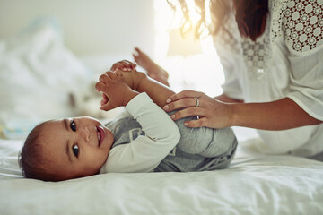 The smile of a child is the most precious sight. Shot of an unrecognizable mother and her adorable baby boy playing together at home.