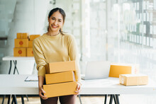 Young Business Woman Working Online E-commerce Shopping At Her Shop. Young Woman Seller Prepare Parcel Box Of Product For Deliver To Customer. Online Selling, E-commerce.