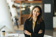 Image of a charming young Asian businesswoman standing at the office. Looking camera.
