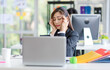 © Bangkok Click Studio - Asian young stressed depressed tired exhausted female businesswoman employee staff in formal suit sitting holding hands at head having problem migraine headache same as businessman colleague behind