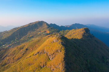 Aerial top view of forest trees and green mountain hills with fog, mist and clouds. Nature landscape background, Thailand.