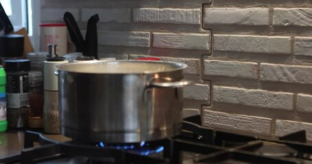 Canvas Print - A pot on fire on gas stove with steam coming out of it