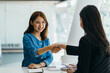 © PaeGAG - Portrait young Asian woman interviewer and interviewee shaking hands for a job interview .Business people handshake in modern office. Greeting deal concept