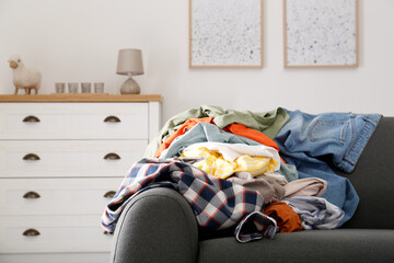 Canvas Print - Messy pile of dirty clothes on sofa in living room. Tidying up method