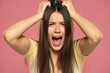 Closeup portrait stressed frustrated woman screaming having temper tantrum isolated on pink background.