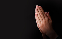 Female Hands Praying On A Dark Background With Copy Space