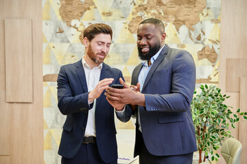 two employees looking at the smartphone screen