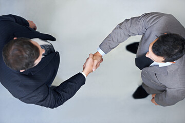 Lets shake on it. High angle view of two businessmen shaking hands.