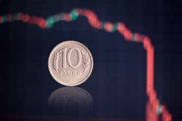 close-up of the ruble on the background of the falling graphics, the concept of inflation, the crisi