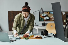 Front View Portrait Of Female Food Photographer Arranging Gourmet Setup With Props, Digital Creator Concept