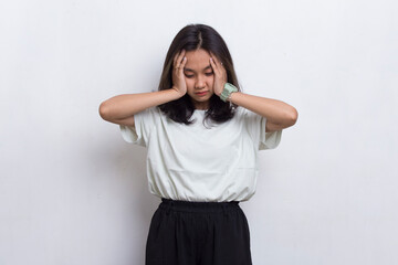 portrait of stressed sick asian beautiful woman with headache on white background
