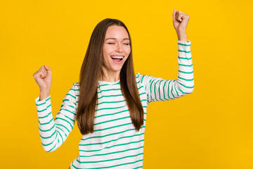 Sticker - Photo of pretty excited lady dressed striped shirt rising fists shouting isolated yellow color background