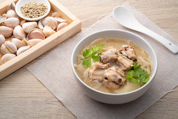 Wall Mural - Bamboo shoot boiled with pork bone in bowl on wooden background.Thai food