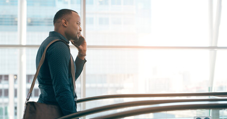 Poster - On call and on the move. Cropped shot of a handsome young businessman taking a phonecall while going up an escalator in a modern workplace.