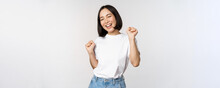 Happy Dancing Korean Girl Posing Against White Background, Wearing Tshirt