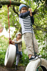 Poster - Swing life away. Shot of two cute kids playing on tire swings in their garden.