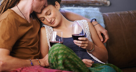 Wall Mural - Heres to our love. Shot of a young dreadlocked couple drinking wine on their sofa.