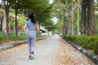 © Chanakon - Happy slim woman wearing sportswear jogging in the city at sunrise. Young beautiful asian female in sports bra running outdoor. Workout exercise in the morning. Healthy and active lifestyle concept.