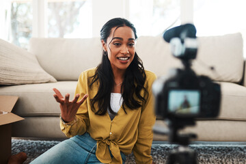 Poster - What do you guys think of this. Cropped shot of an attractive young businesswoman sitting in her living room and using her camera to record her vlog.