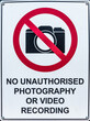 A No Photography street sign with black text on a white background and a red graphic shape