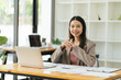 © PaeGAG - Charming asian businesswoman sitting working on laptop in office.