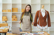 © PaeGAG - Female fashion designer works on new womenswear collection for clients in cozy workshop studio, dressmaker, tailor or needlewoman standing near clothing rack with fashionable stylish handmade clothes