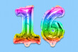 © Marina Kaiser - Rainbow foil balloon number, digit sixteen on a blue background. Birthday greeting card with inscription 16. Anniversary concept. Top view. Numerical digit. Celebration event, template.