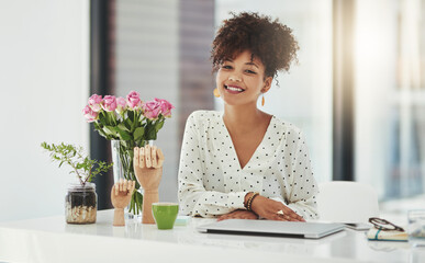 Wall Mural - Success is her game. Shot of a beautiful young businesswoman working in her office.