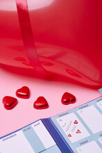 Heart-shaped Candies And Calendar On Pink Background