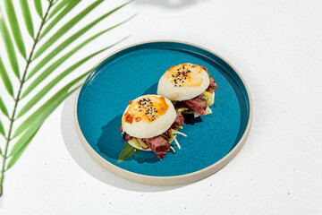 Bao buns with beef and vegetables. Chinese buns on ceramic plate on white background. Asian street food - bao with roast beef and fresh vegetables.