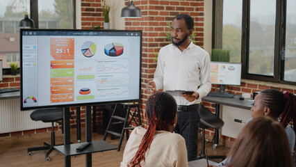 Poster - african american man doing financial presentation with charts, talking about business growth to coll