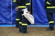firefighter holding a radiator in his hand in order to mount it in a tent to heat it. tents for refugees in Ukraine.