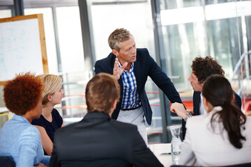 Poster - distributing tasks to the team. cropped shot of a group of business professionals in an office meeti