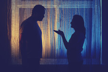 Wife Asks Her Husband For Forgiveness. Silhouette Of Man And Woman At Night Window, Concept Of Domestic Quarrel
