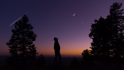 Wall Mural - man observing evening sky with stars, planets and crescent moon.