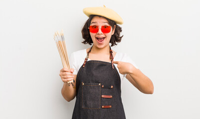 Wall Mural - pretty hispanic girl feeling happy and pointing to self with an excited. art student concept