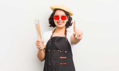 Wall Mural - pretty hispanic girl smiling and looking friendly, showing number one. art student concept