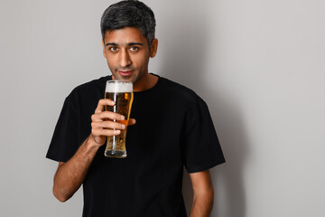 Sticker - Handsome man drinking beer on light background