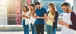 © Delmaine Donson/peopleimages.com - This is the world we live in now. Cropped shot of a group of young people texting on their cellphones while standing outdoors.