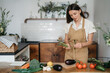 © Oleksandr - Young Woman Cooking in the kitchen at home. Healthy Food. Diet. Dieting Concept. Healthy Lifestyle. Cooking At Home. Prepare Food.A woman holding fresh organic vegetables in her hands