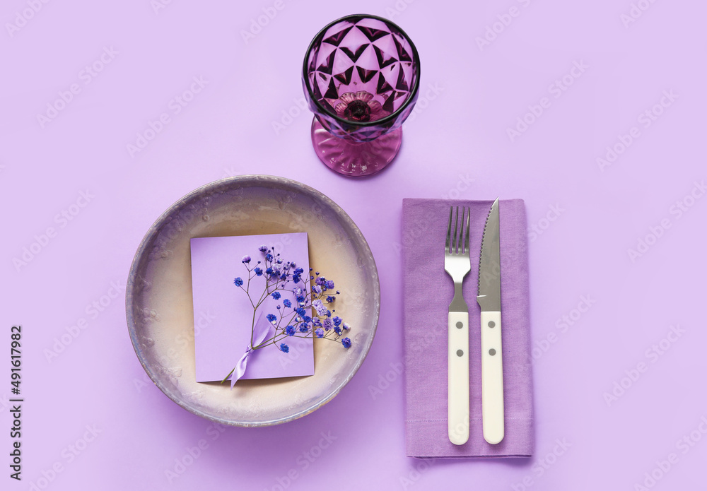 Simple table setting with flowers on purple background