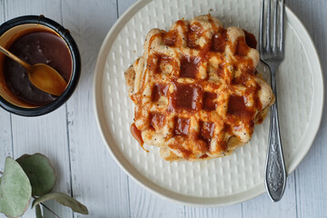 Sticker - Poppy seed waffles with caramel sauce. Wooden background. Top view. 