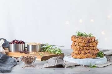 Raw veggie burger with quinoa, red beens, vegetables and rosemary leaves on kitchen countertop