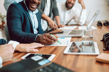 Unrecognizable colleagues working with documents