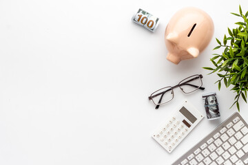 Piggy bank on office table with keyboard and calculator. Financial planning concept