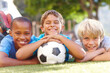 © STEEX/peopleimages.com - A winning team of best friends. Three happy boys lying outside in the sun with their soccerball - copyspace.