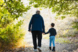 © ADDICTIVE STOCK - Unrecognizable grandfather and grandson walking in forest during autumn