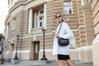 Young fashion blonde woman in trendy outfit posing in the city. Street fashion