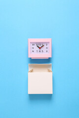 Wall Mural - New alarm clock with box on blue background. Top view